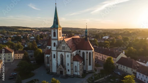 Wallpaper Mural Ancient church with tall spire, surrounded by a European town and rolling hills at sunset Torontodigital.ca