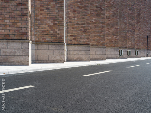 Fototapeta Naklejka Na Ścianę i Meble -  Brick building, paved road, small vents and street lamp