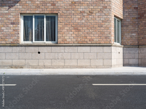 Fototapeta Naklejka Na Ścianę i Meble -  Brick building, paved road, small vents and street lamp
