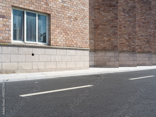 Fototapeta Naklejka Na Ścianę i Meble -  Brick building, paved road, small vents and street lamp