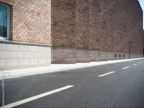 Fototapeta Naklejka Na Ścianę i Meble -  Brick building, paved road, small vents and street lamp