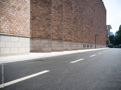 Fototapeta Naklejka Na Ścianę i Meble -  Brick building, paved road, small vents and street lamp