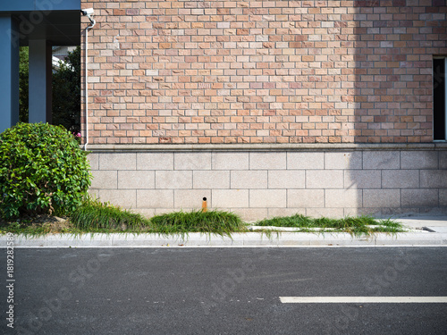 Fototapeta Naklejka Na Ścianę i Meble -  Brick building, paved road, small vents and street lamp