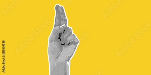Fingers crossed hand gesture on yellow background for good luck