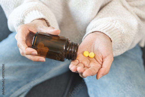 Sick asian young woman, girl holding tablet pill on hand pour capsule from medication bottle, painkiller medicine from stomach pain, head ache, pain for treatment, take drug or vitamin, health care.