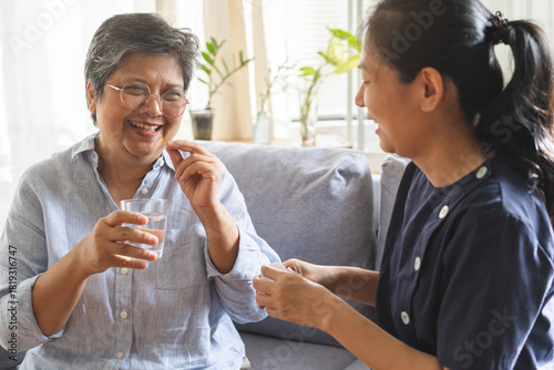 Foto Asian young woman caregiver, carer support elderly, aged patient sit on sofa at