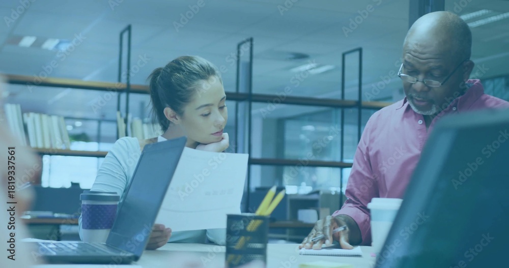 Obraz premium Reviewing printed document, woman and senior man in button-up shirt pointing at notebook in office