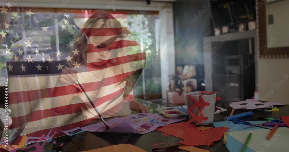 Naklejka premium Painting child in light-colored top using paintbrush at home craft table, flag overlay, paints