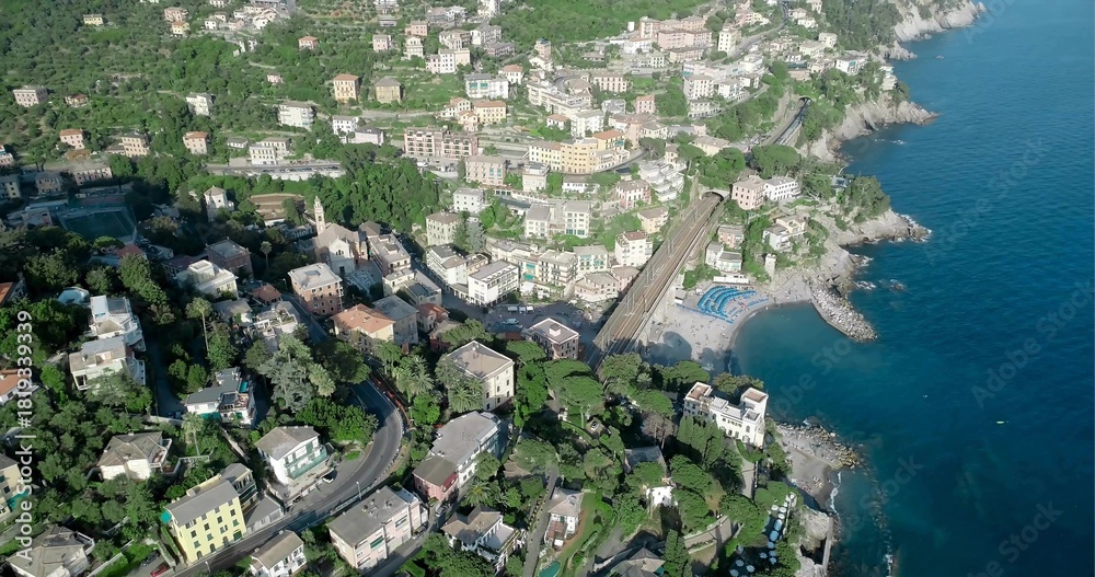 Naklejka premium Capturing pastel buildings clustering on steep terraced hillside by rocky shore with blue umbrellas