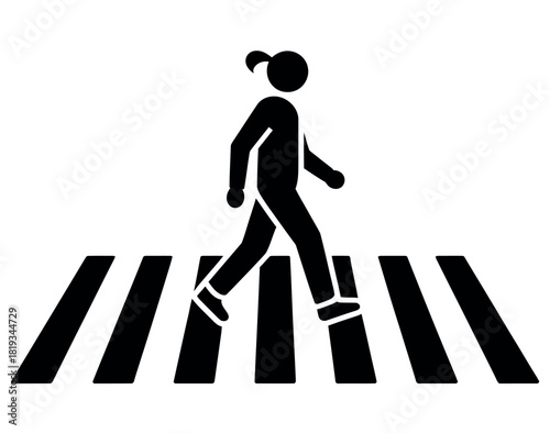 A pedestrian crosses a street at a zebra crossing.