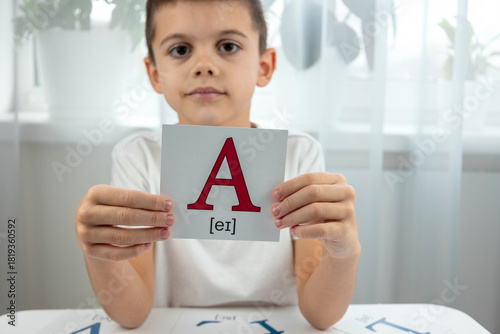 Bilde på lerret Boy holding a flashcard with the capital letter A and its phonetic transcription