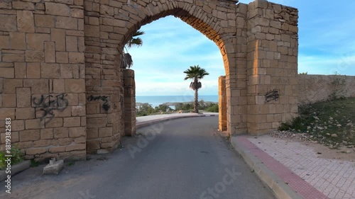 Historic Stone Arch with Road and Palm Tree, Oualidia, Morocco