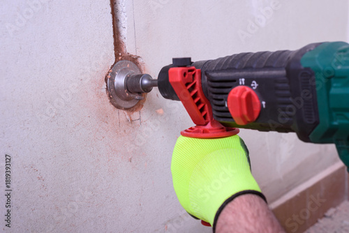 Contractor with hammer drill doing hole for socket
