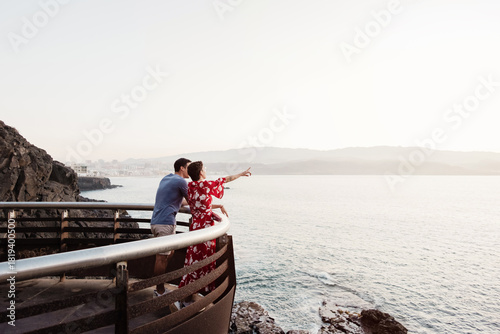 Couple watching ocean view from coastal viewpoint on holiday