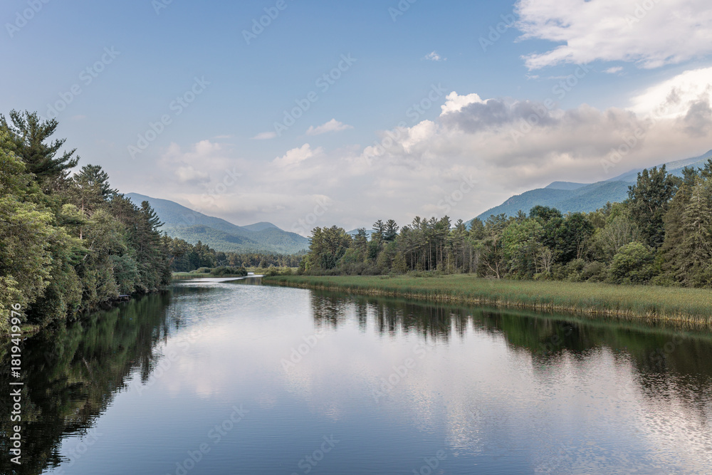 Obraz premium Serene nature landscape in Lake Placid, NY of the Ausable River and the Adirondack Mountains with blue skies.