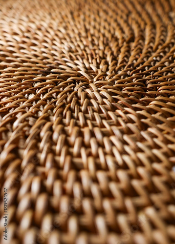 Close up of natural wicker weave creating a spiral pattern, showing craft and intricate texture