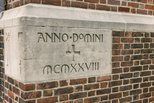 Historic stone inscription on a brick building from the year 1928 in a city setting