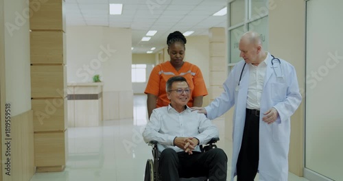 (Thai wording translation: Prescribe medici)Hospital concept of 4k Resolution. The stretcher staff is pushing a wheelchair for the patient, while the doctor is talking and asking about their symptoms.