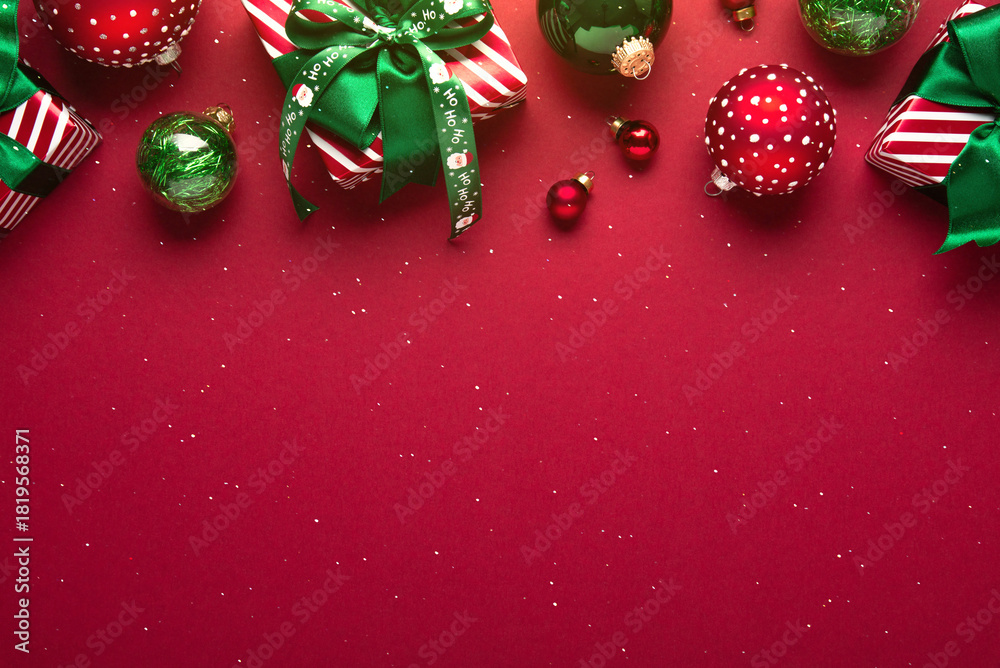 Obraz premium Merry Christmas and Happy Holidays greeting card, frame, banner. New Year. Red Christmas ornaments and gifts, presents on red background top view. Xmas holiday festive theme. Christmas decoration