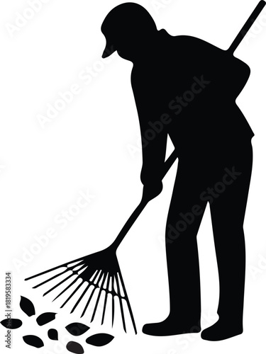Silhouette of a person raking leaves during autumn season