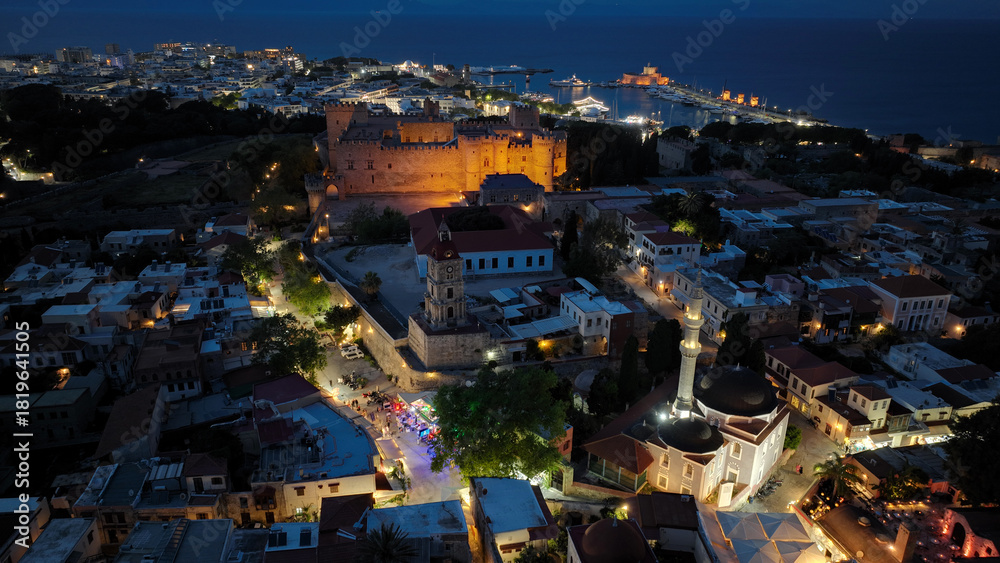 Naklejka premium Aerial drone night shot of iconic Palace of the Grand Master in old town of Rhodes island, Dodecanese, Greece