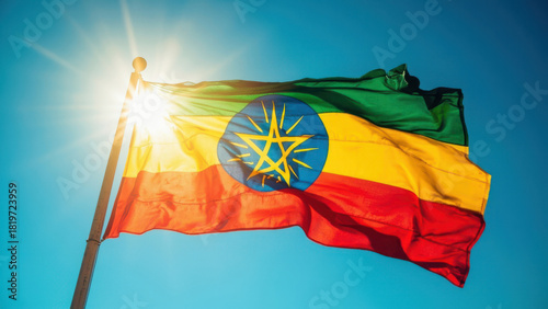 Ethiopian flag waving in the wind with bright sun and clear blue sky