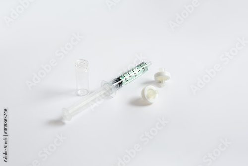 A syringe containing a sample solution alongside syringe filters and a glass vial, used for laboratory sample preparation and filtration in analytical methods such as HPLC and LC-MS.