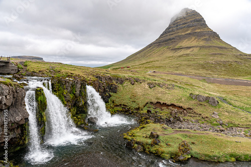 Kirkjufellsfoss waterfall and Mount Kirkjufell covered by clouds on the Snaefellsnes Peninsula in western Iceland