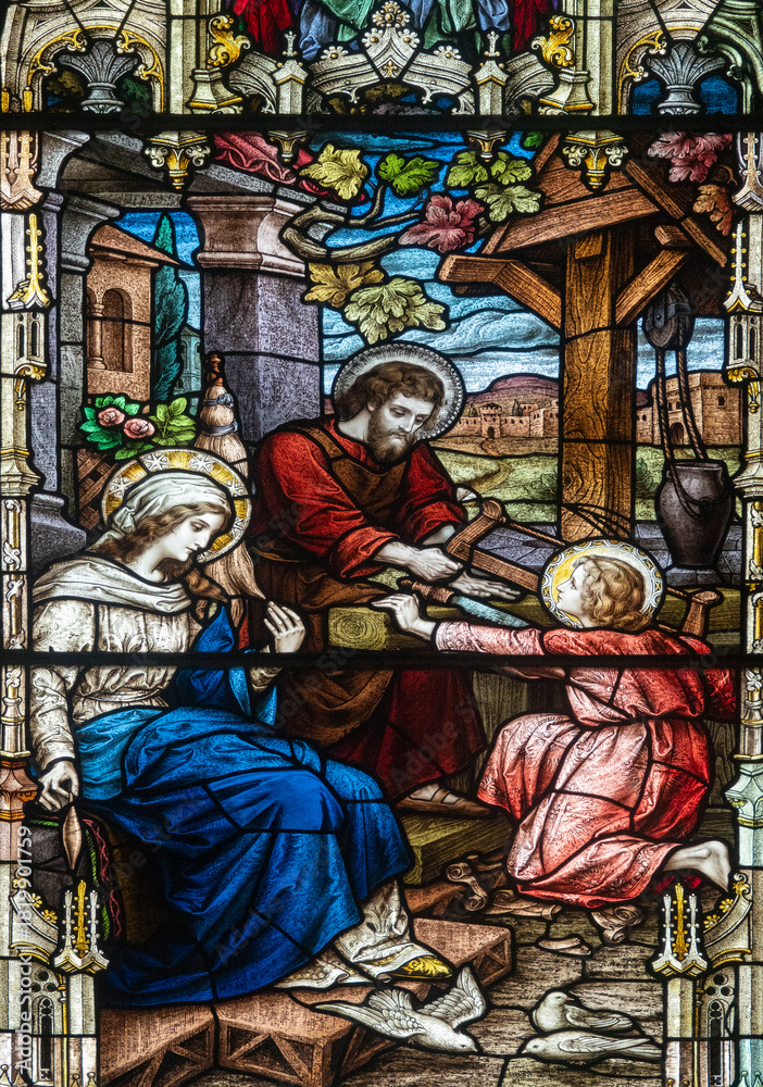 Obraz premium Stained glass (19th century) of Holy family: Jesus infant, Virgin Mary and St Joseph in the workshop of Joseph the carpenter.