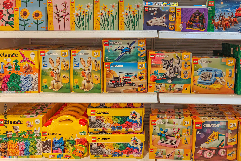 Obraz premium Valencia, Spain - November 18, 2025: LEGO boxes featuring popular series such as LEGO Creator, and LEGO Classic are arranged on toy store shelves. LEGO is Danish brand of plastic building bricks.