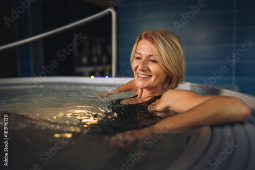 Foto Senior woman enjoying hydrotherapy in a spa hot tub