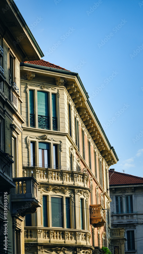 Obraz premium Balconies in the historic district of Milan, Italy, illuminated by warm sunset light, with ornate architecture and romantic atmosphere