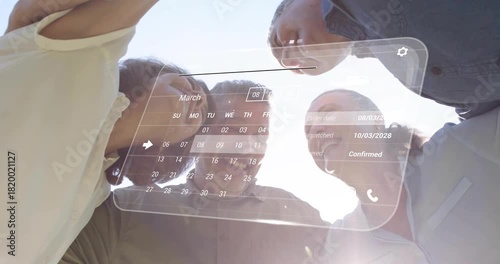 Four adults leaning over camera, AR calendar appearing and updating while confirming March orders