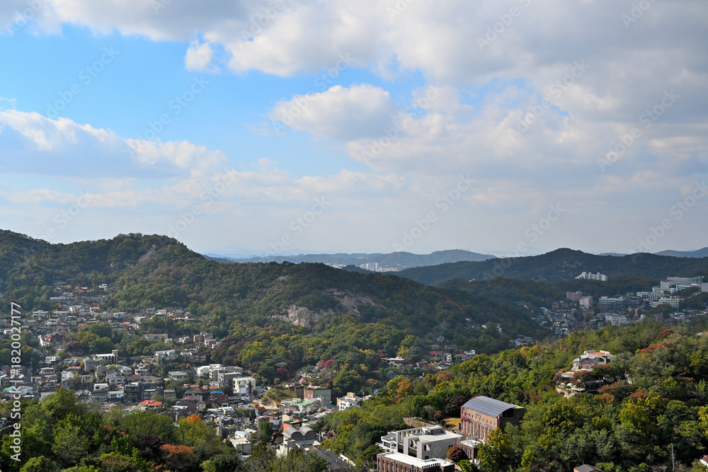 Obraz premium A village under a mountain in autumn under a rather cloudy blue sky