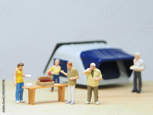 Mini toy of action figure at outdoor with blur background. Miniature photography concept design. Minifigure of traveler character with tent at camping ground. Holiday, vacation and traveling at hill.