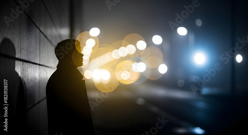 Silhouette of a man standing in the night with blurred lights in the background.