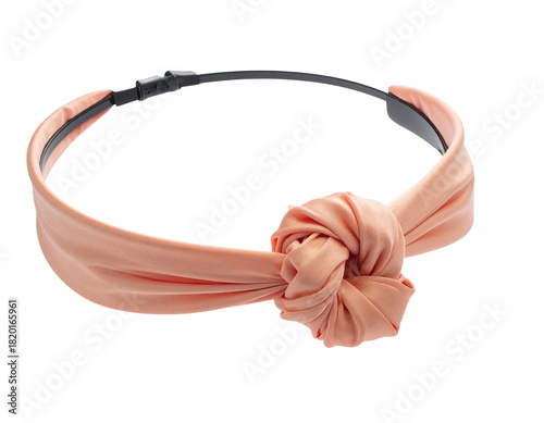 Peach-colored fabric headband with a large knotted design, resting on a black base