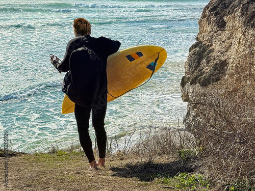 Photography Man carrying surfbaord approaches the ocean to go surfing at 3 mile beach
