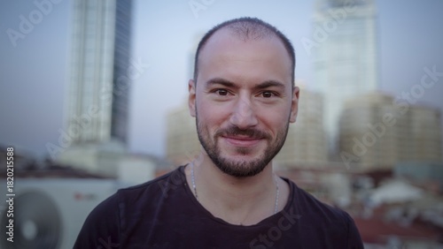 Smiling man with urban background in soft light