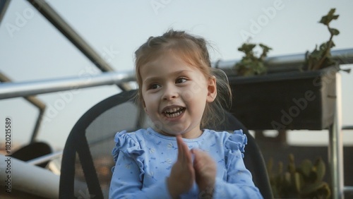 Happy child clapping hands outdoors in evening light