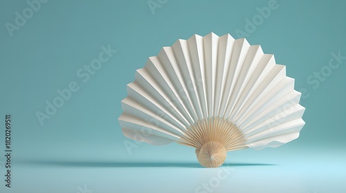 White pleated hand held accessory rests on a light blue surface against a matching backdrop