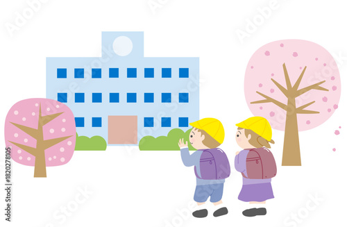 桜の咲く小学校へ向かうランドセルを背負った1年生の男の子と女の子