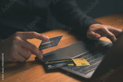 Фотография Person using a credit card with a laptop, representing digital banking, financial transactions, pay off the credit card, and secure internet shopping technology