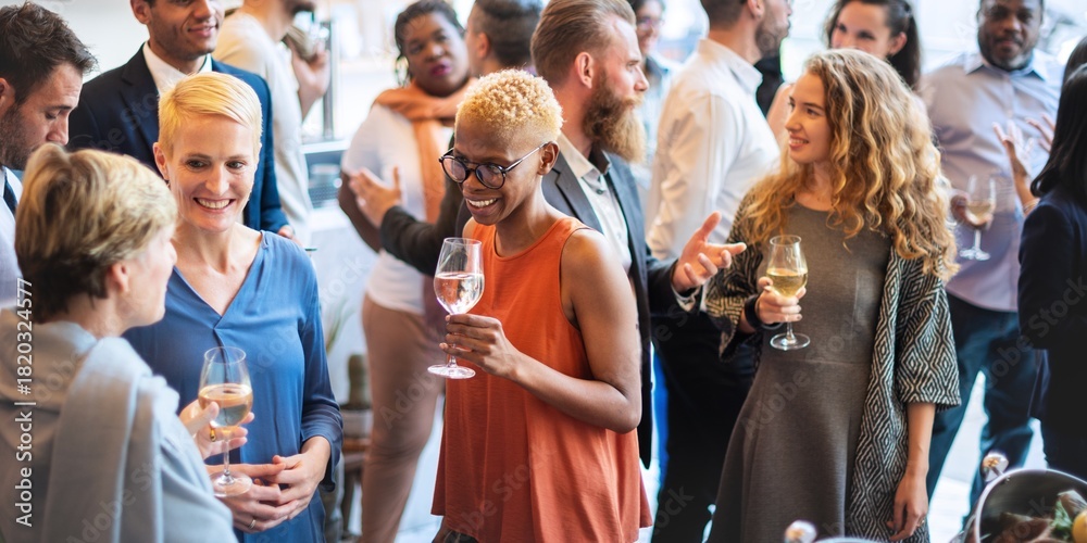Fototapeta premium Diverse group at a social event, mingling and enjoying drinks. People of various ethnicities and genders are engaged in lively conversation and networking. Diverse people mingle at a social event.