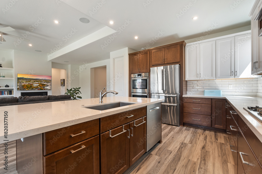 Fototapeta premium A modern kitchen with stainless steel appliances and wooden cabinets