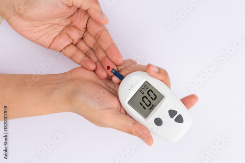 Woman's hands checking diabetes and hyperglycemia with digital blood sugar meter. Healthcare and medical concept	