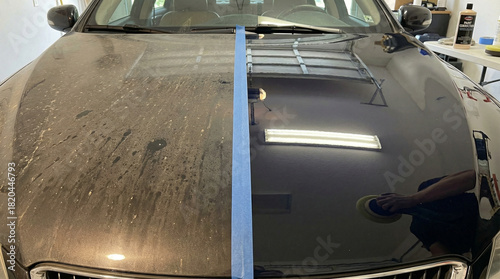 Car hood showing a before and after comparison of paint correction with tape dividing the dirty and polished side