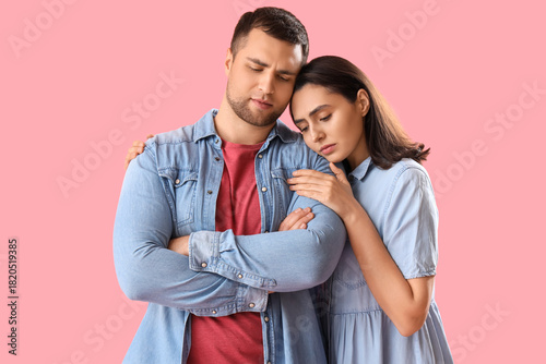 Sad young couple hugging on...
