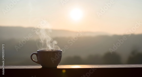 Morning coffee with steam against a hazy sunrise landscape view