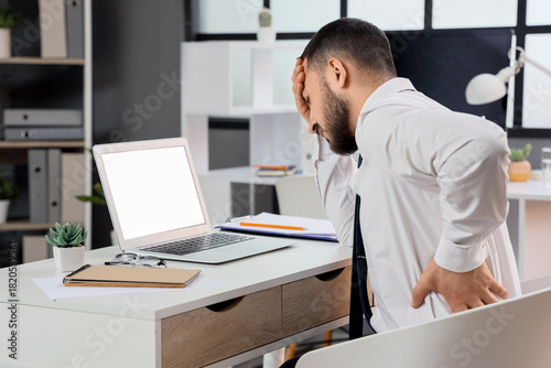 Young businessman suffering...